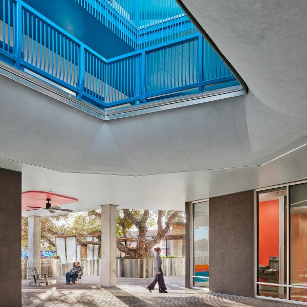 Woman walking under blue staircase