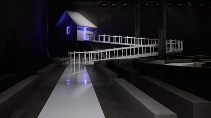 House on catwalk lit by purple light