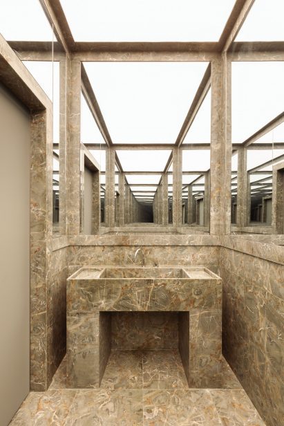 Bathroom with green marble inside store designed by Halleroed 