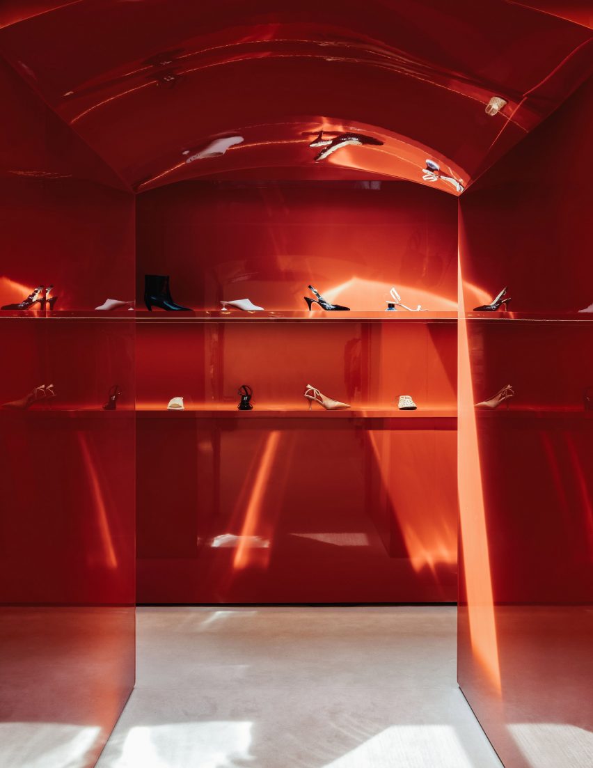 Coral red arched tunnel with shoes displayed on shelves