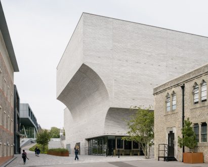 Curved facade clad in grey brick and flint