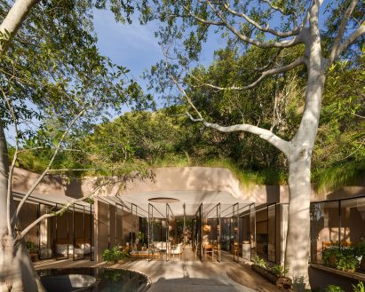 Building with a wavy roofline that avoids existing trees