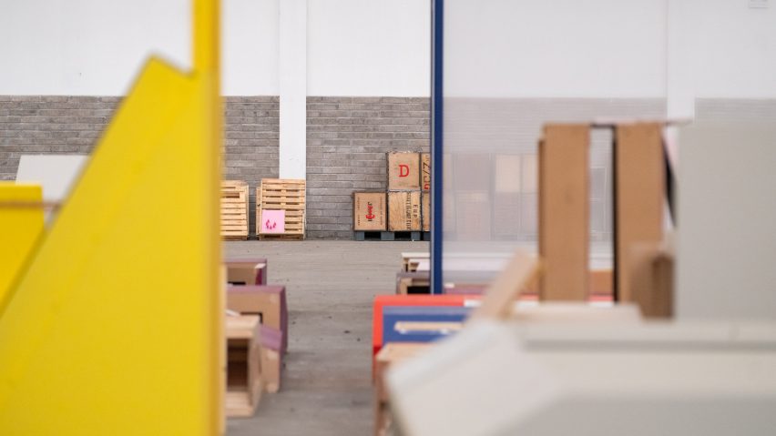 Close-up photo of painted wood frames, pallets and other construction materials stacked up in small piles at a warehouse