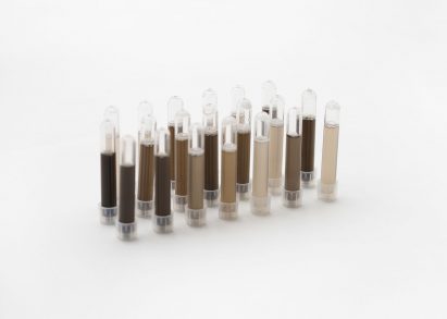 Photo of a tray of test tubes containing skin-coloured liquids from light beige to dark brown
