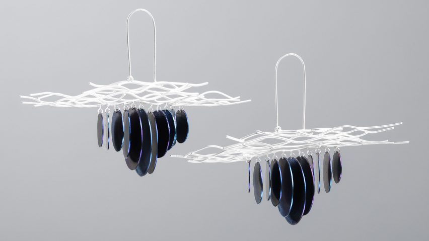 A photograph of two pieces of jewellery against a grey background, with silver, blue and purple iridescent elements.