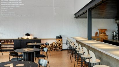 Double-height restaurant interior with menu projected onto the wall