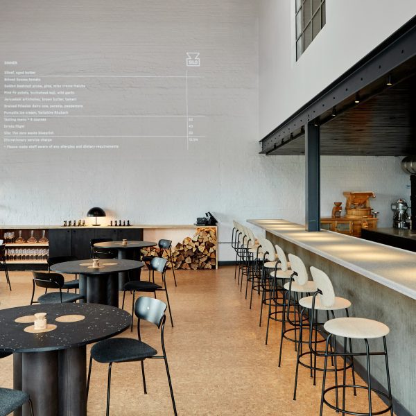 Double-height restaurant interior with menu projected onto the wall