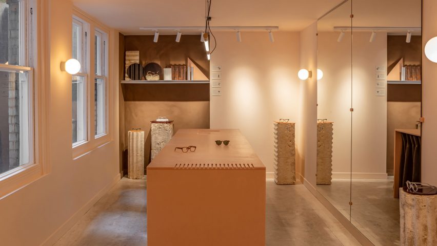 Eyewear shop interior with centrally-placed orange table