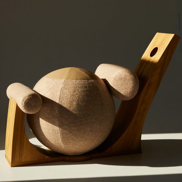 A photograph of an abstract wooden chair in circular structures, against a dark grey background.