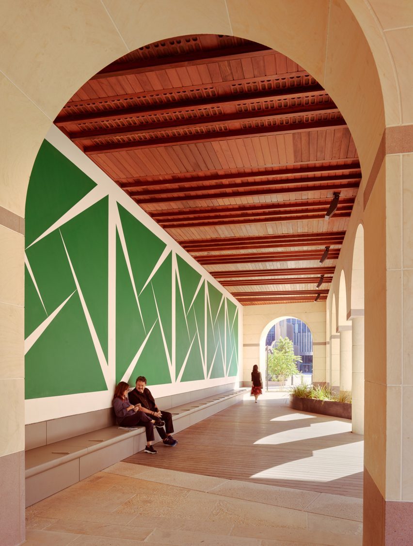 A large green mural underneath a loggia