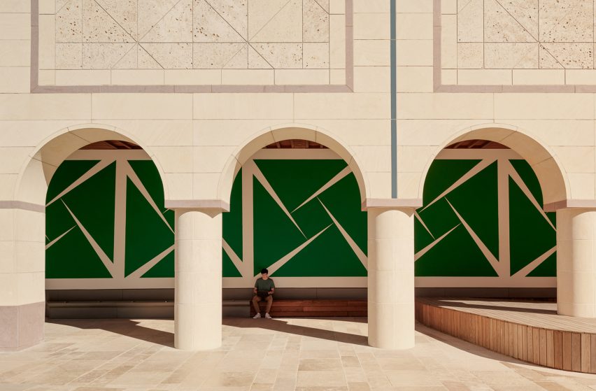 A large green mural underneath a loggia