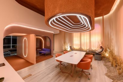 Room with a central dining/meeting table below a large light fixture