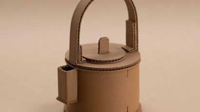 A photograph of a brown ceramic teapot against a brown backdrop.