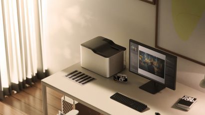 A visualisation of a room in neutral tones with a computer and another device on a desk.