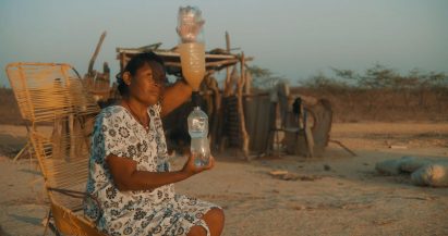 Woman holding two water bottles connected by a filter cap