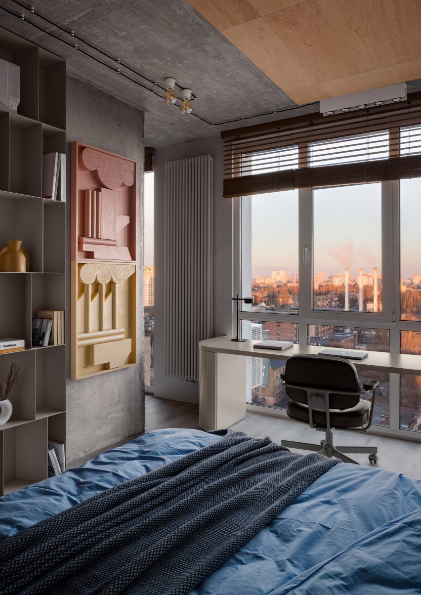 Bedroom with concrete pillar and desk with views over Kyiv