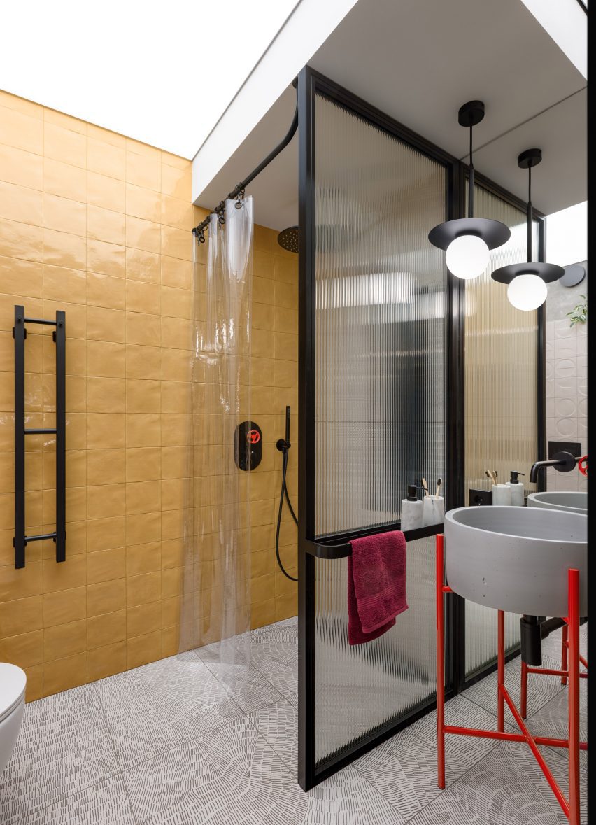 Yellow tiles and textured glass in bathroom