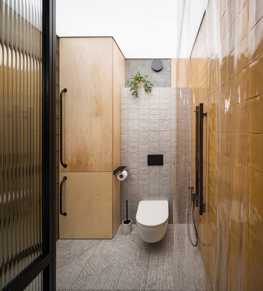 Bathroom with yellow walls and plywood cabinets