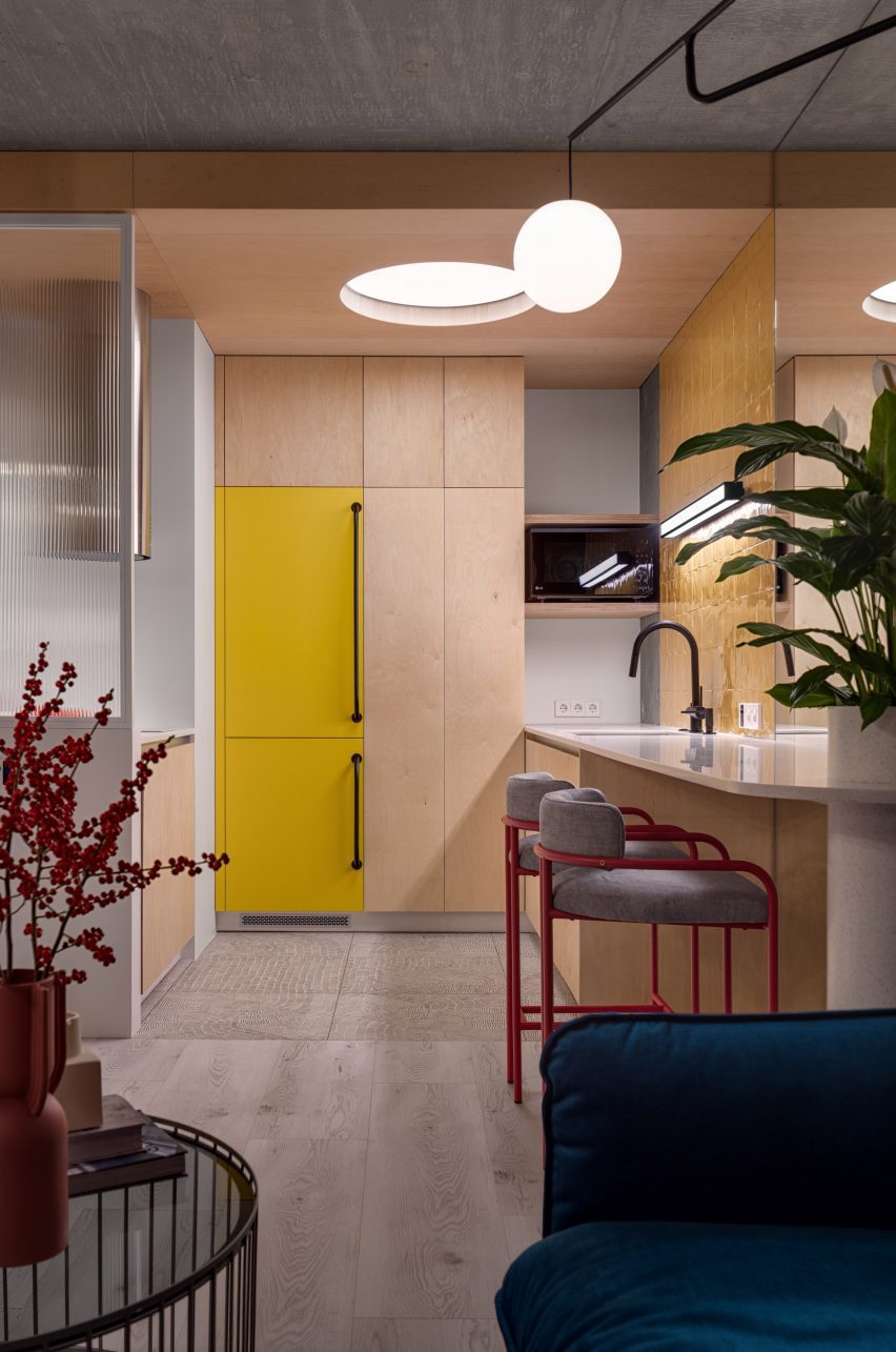 Plywood and concrete kitchen with yellow cabinets