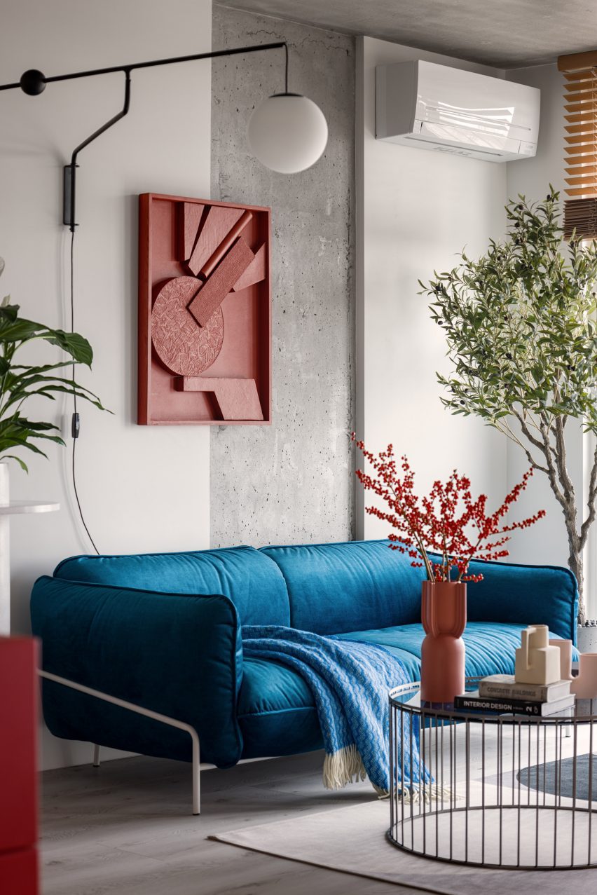Blue velvet sofa with wall panel by artist Tasha Oro
