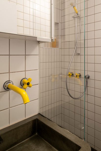 Bathroom with yellow taps in Trellick apartment by Archmongers