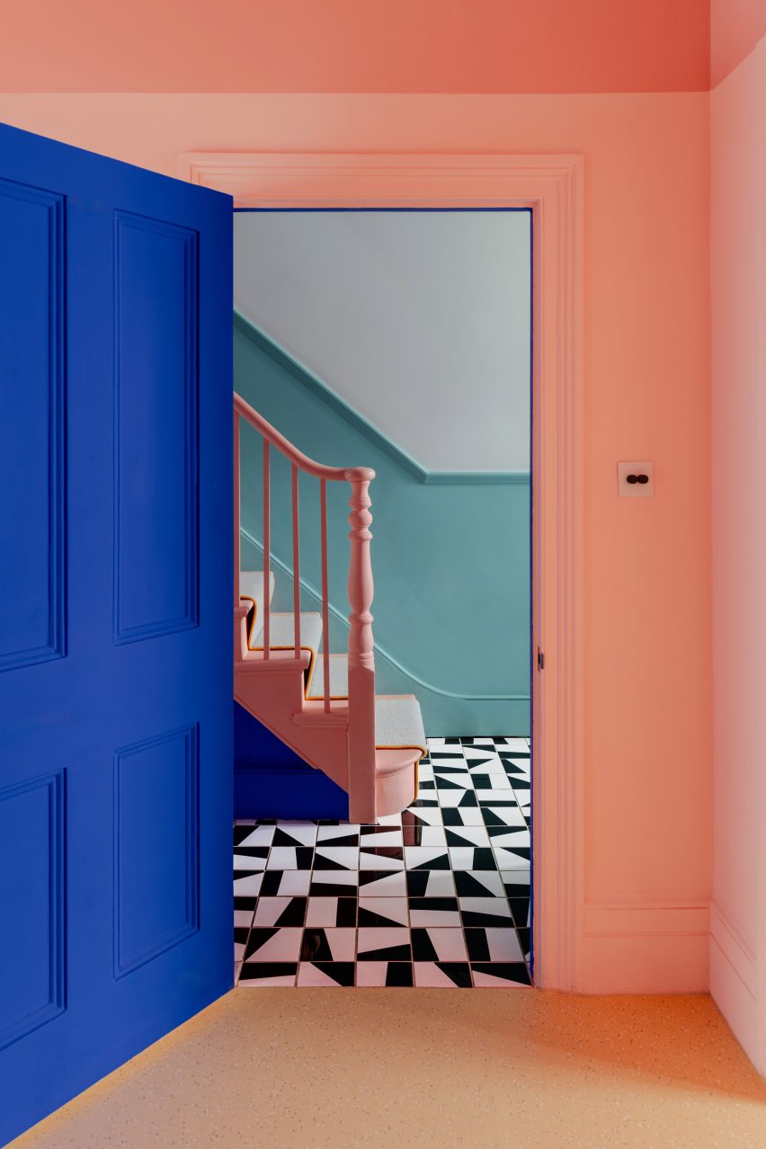 Hallway with monochrome floor tiles and pink banister