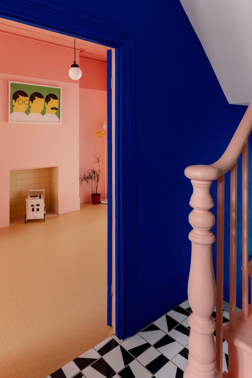 Hallway with monochrome floor tiles and pink banister
