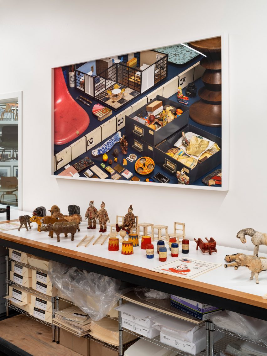 A desk with items underneath and painting on wall