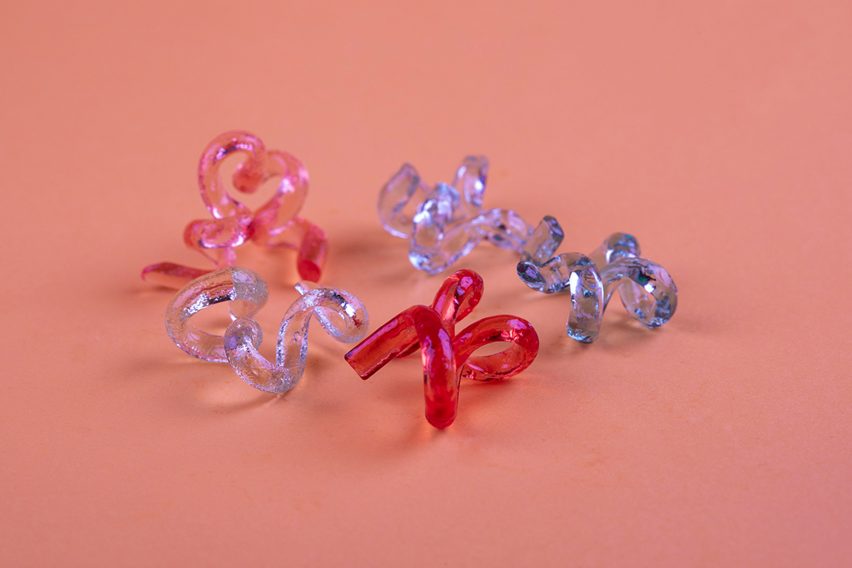 Photo of twisted-up glossy multi-coloured candies against a pink background