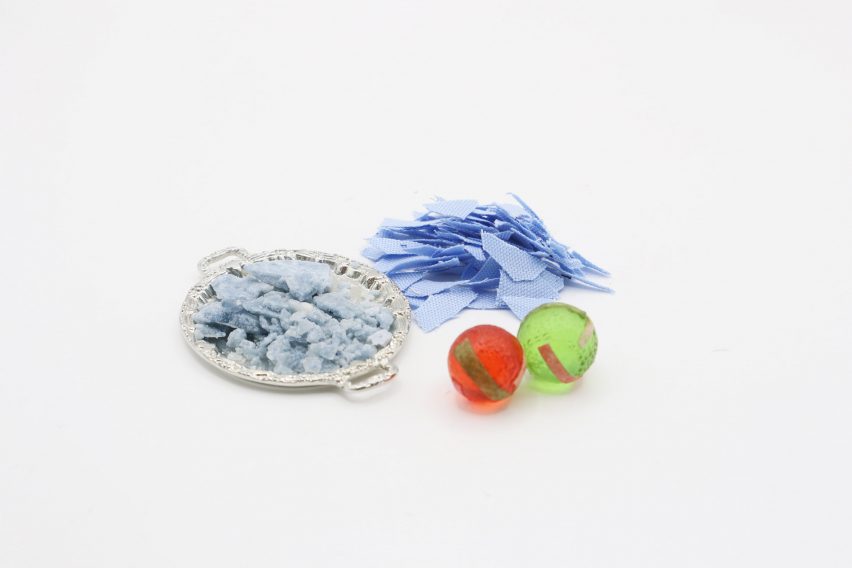 Photo of light blue fabric scraps beside two bright spherical hard candies