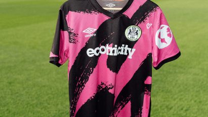 Pink football shirt on hanger above grass pitch