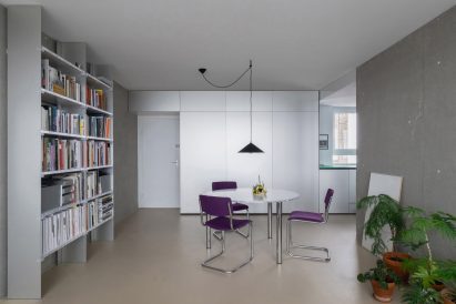 Dining space with bookcase and cantilever chairs around small circular table