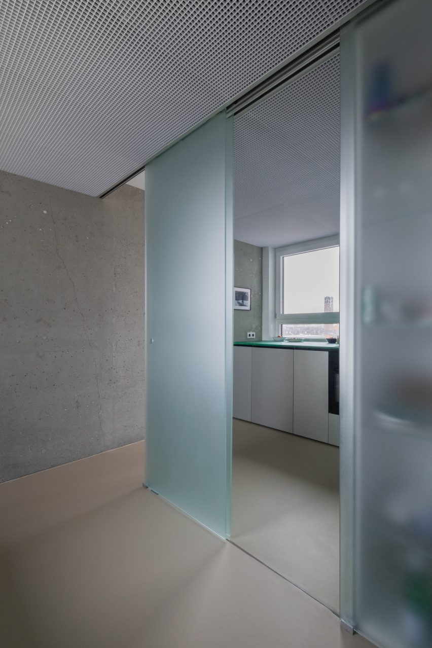 View from bathroom into kitchen through glass sliding doors