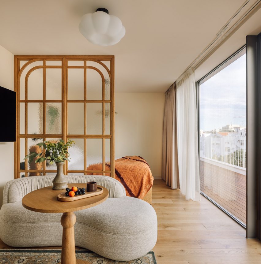 Glass and wood screen dividing living space from bed
