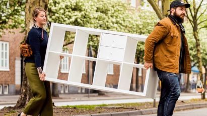 Two people carrying an IKEA cupboard