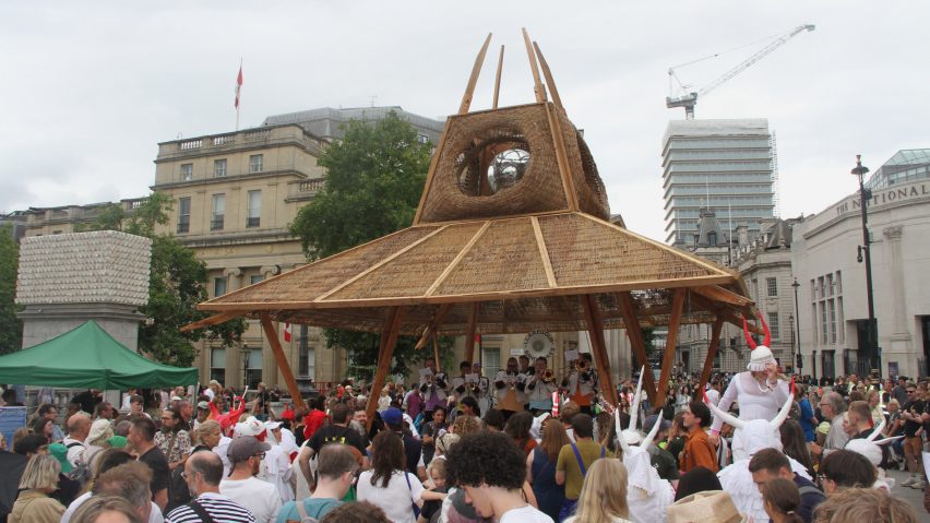 a photograph of a group of people around a brown architectural structure