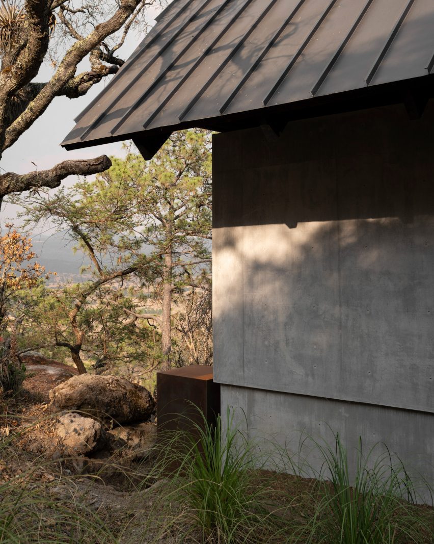 Black roof overhangs with concrete wall
