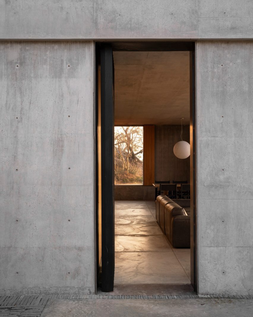 Concrete wall with open door looking into living room