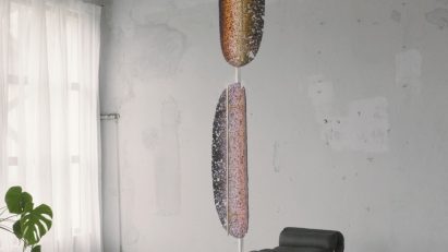Studio Furthermore's Quasar Lamp suspended from the ceiling in a contemporary interior