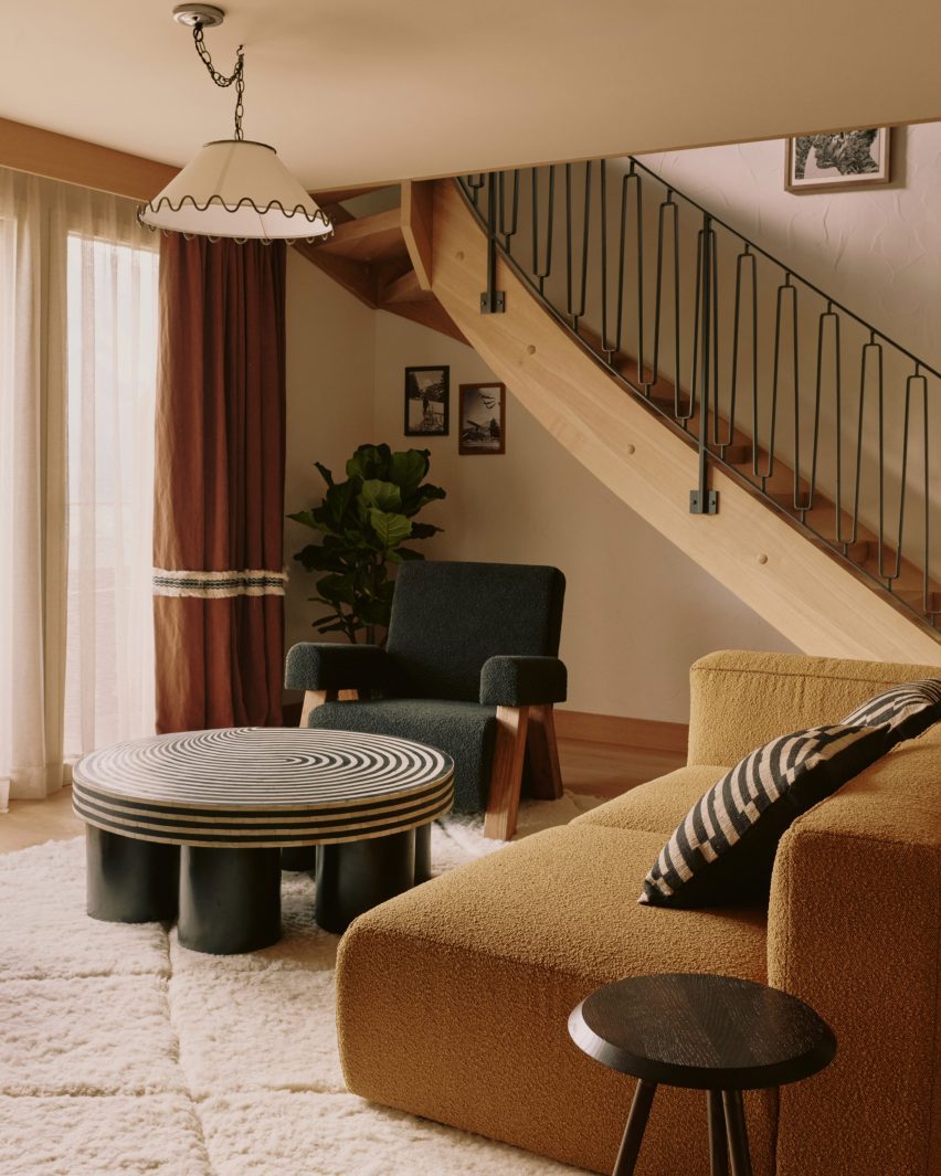 Sofa and coffee table with curving staircase behind