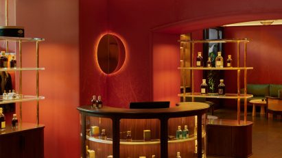 Photograph of a decorative red hotel interior with a curved bar unit.