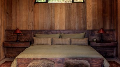 Wood lined bedroom with green bedsheets