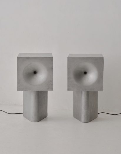 Two metal speakers on a white backdrop