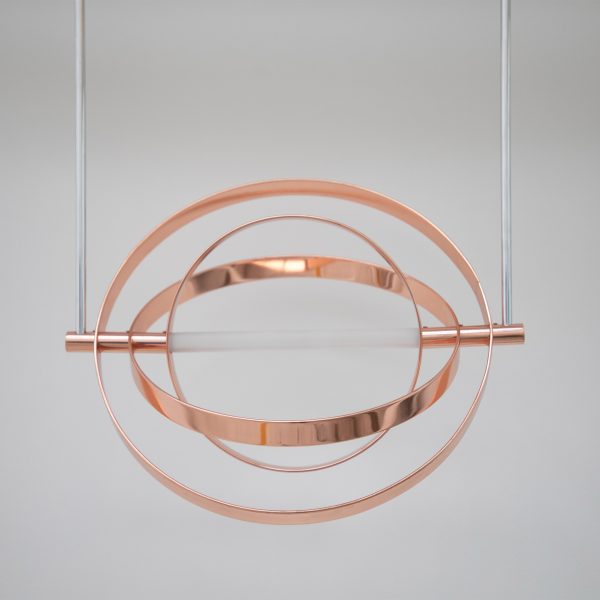 A photograph of a hanging circular metal installation in copper tones.