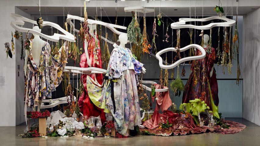 Photograph of an installation with mannequins wearing bright patterned textiles.