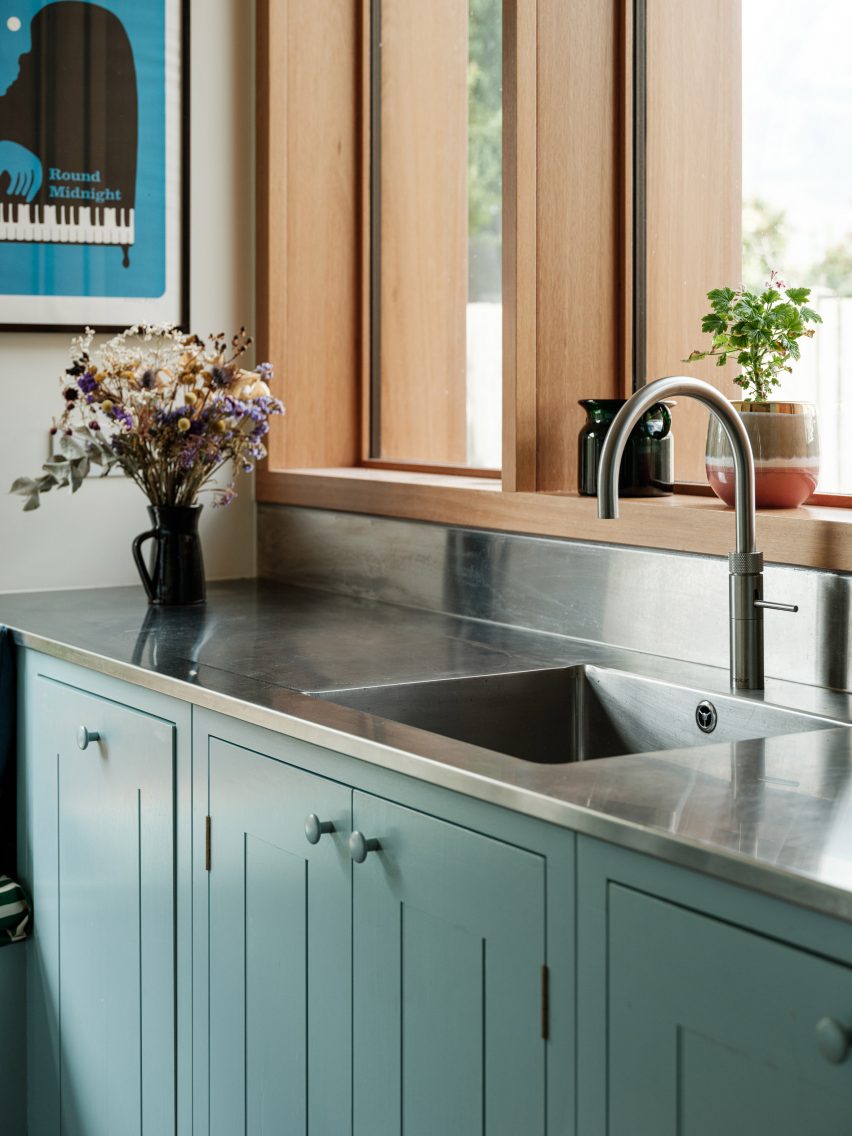 Steel kitchen countertop contrasted against blue cabinets