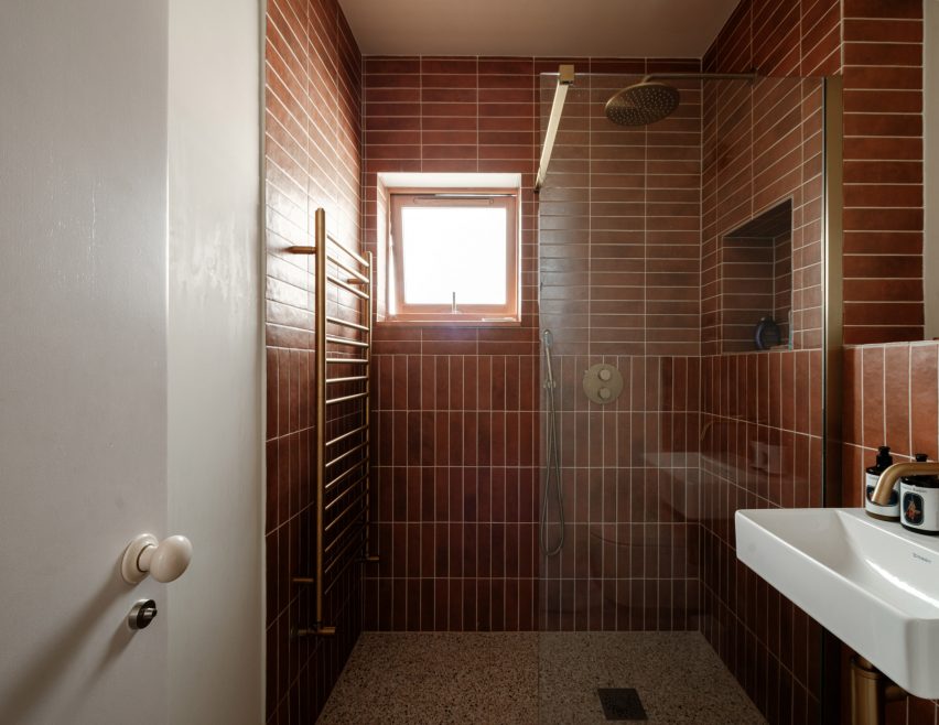Deep orange tiled shower area