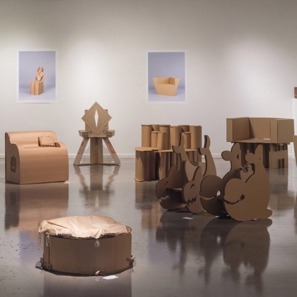 A photograph of an exhibition of brown cardboard chairs