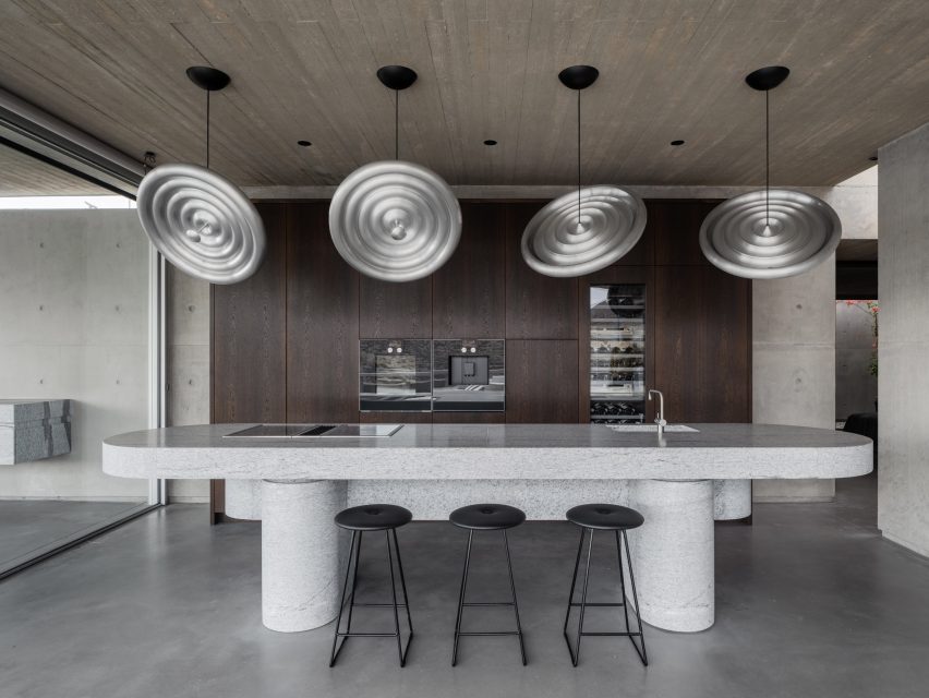 Custom disk-shaped lighting by Tom Dixon were suspended over the kitchen island