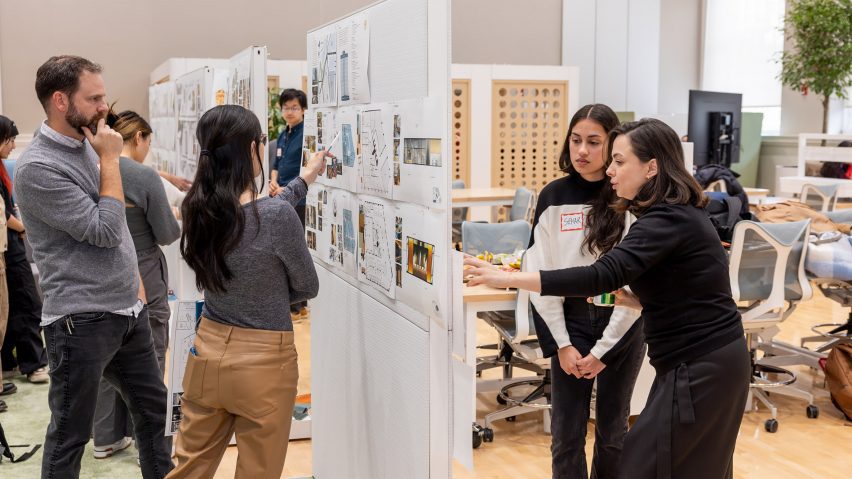 A photograph of people at a university discussing their work with professors.